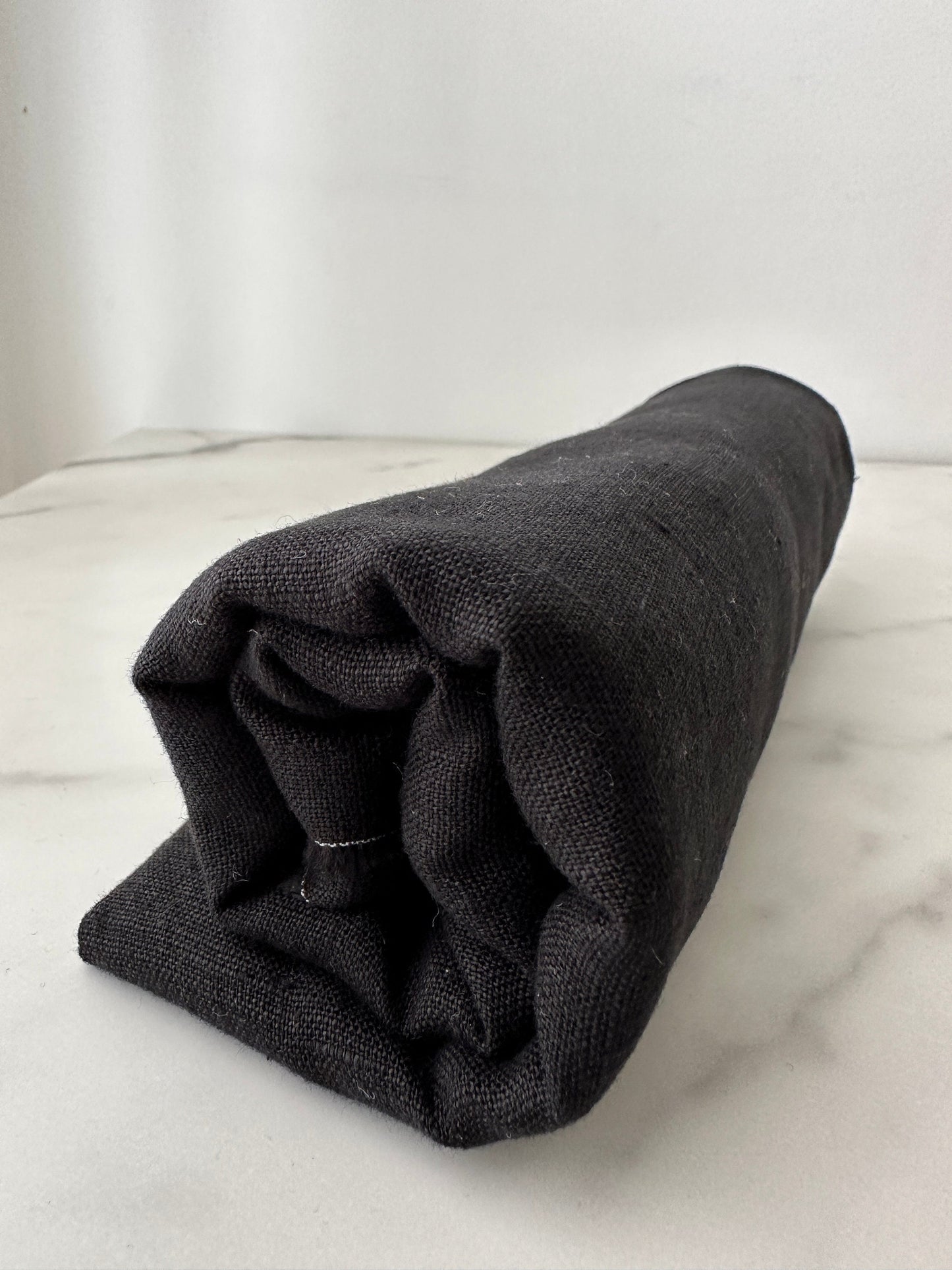 dark black european linen fabric rolled on table