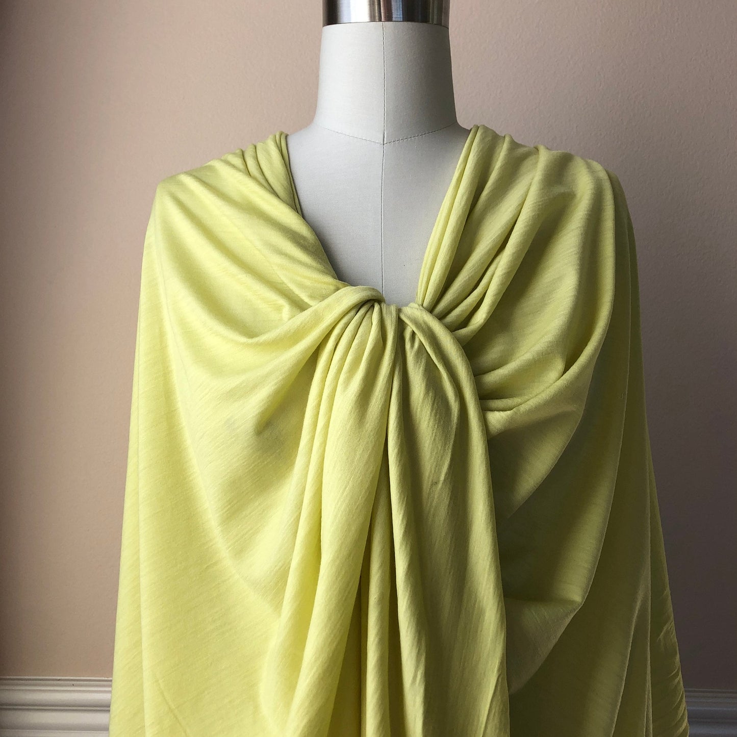 Lightweight soft 100% merino wool jersey fabric draping on a dress form.