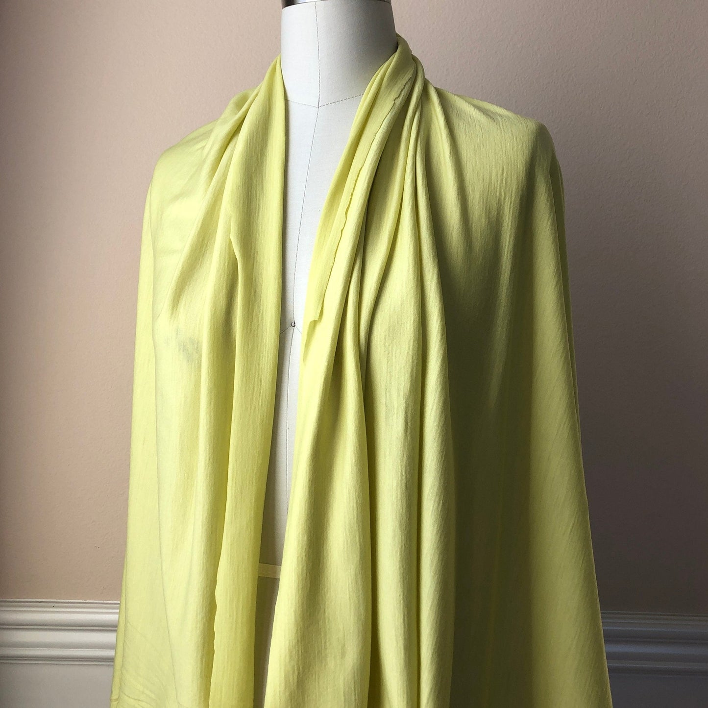 Merino wool fabric showcasing as an open cardigan on a dress form .