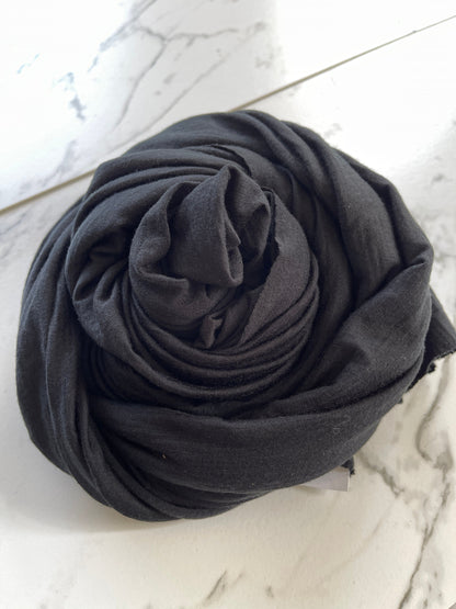 Angle view of swirled true black color merino wool jersey.