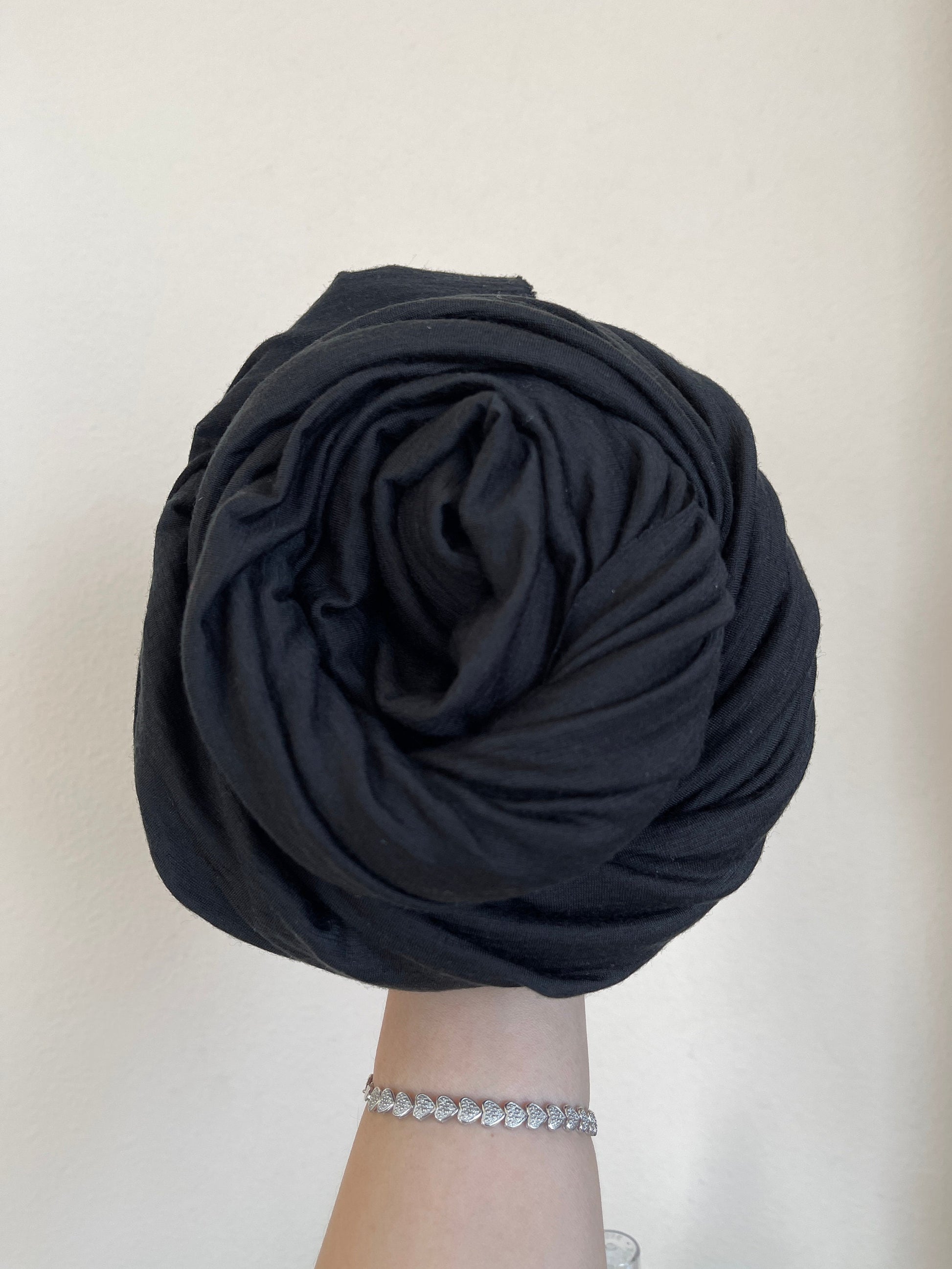 True Black color merino wool held against the wall under natural light.