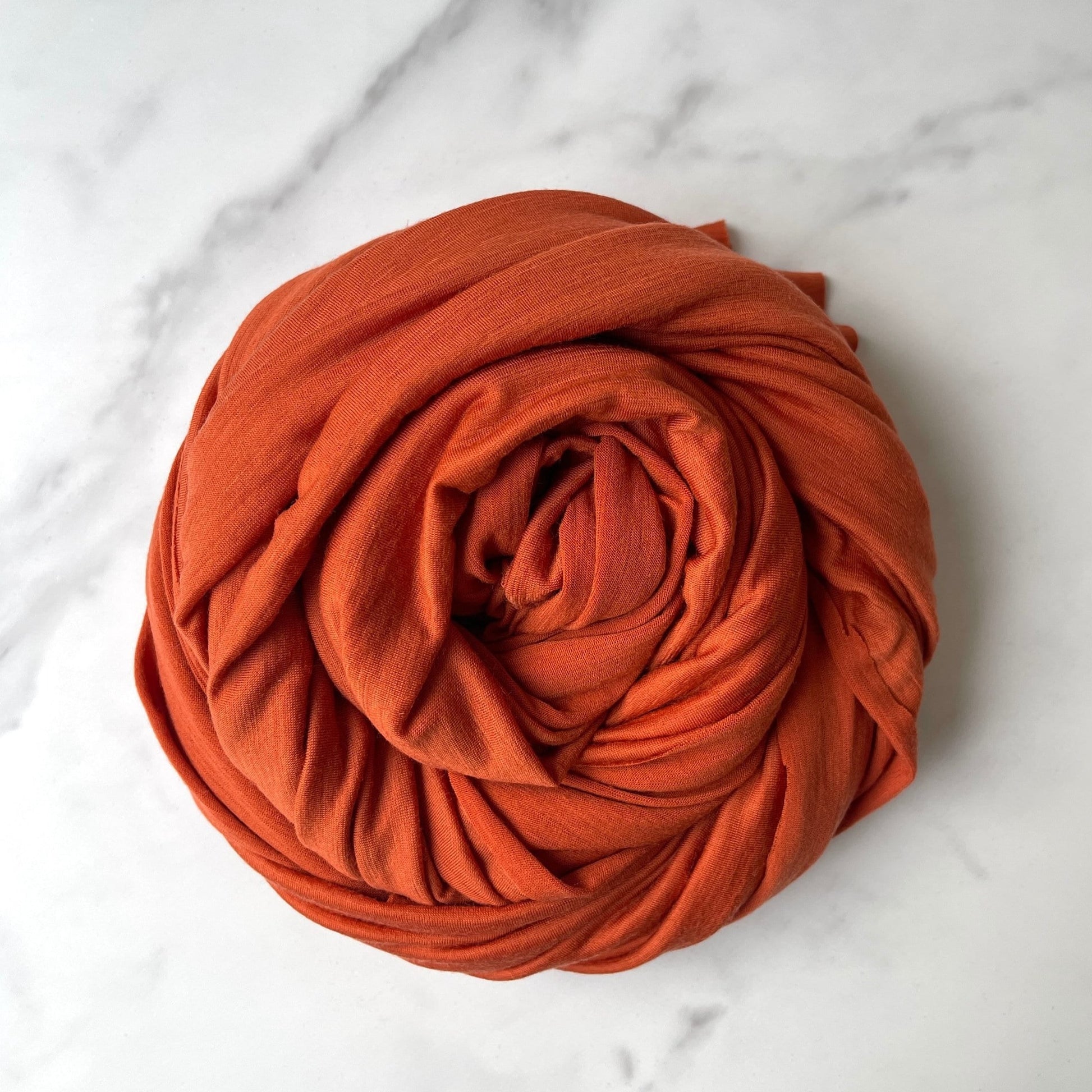 Soft merino wool fabric in earthy orange color.