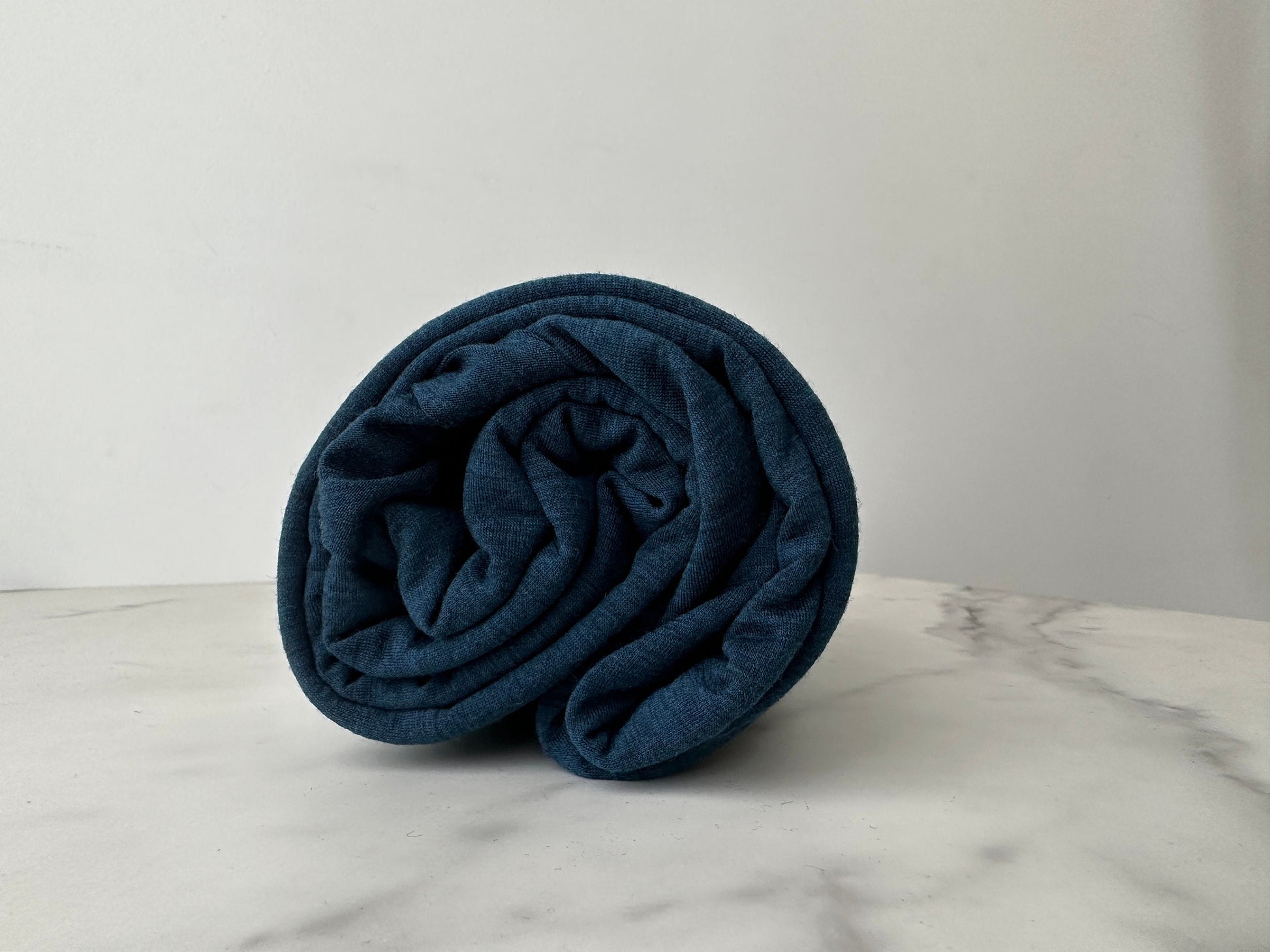 A roll of merino wool fabric displayed.