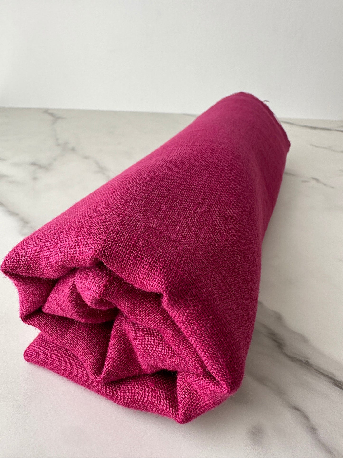 magenta linen fabric rolled and look from far