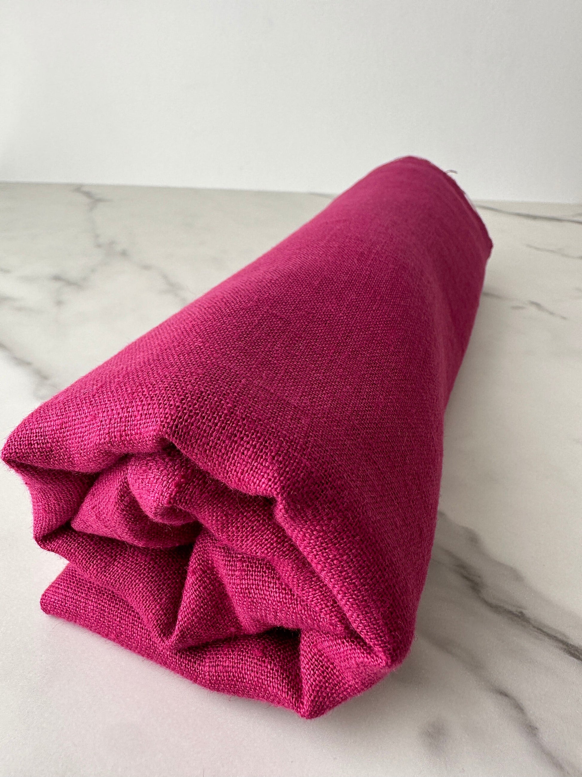 magenta linen fabric rolled and look from far
