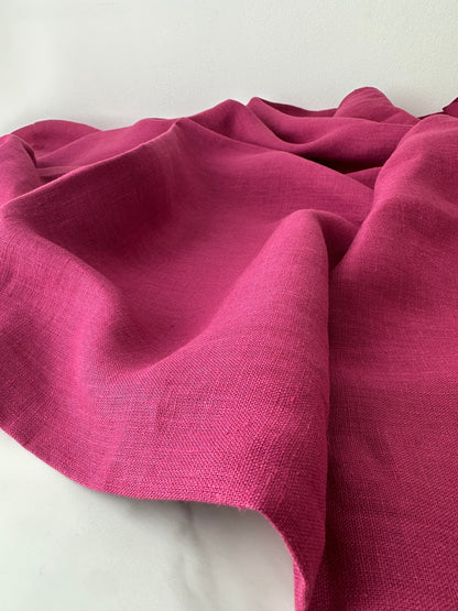 magenta linen fabric roll out and shown on flat surface