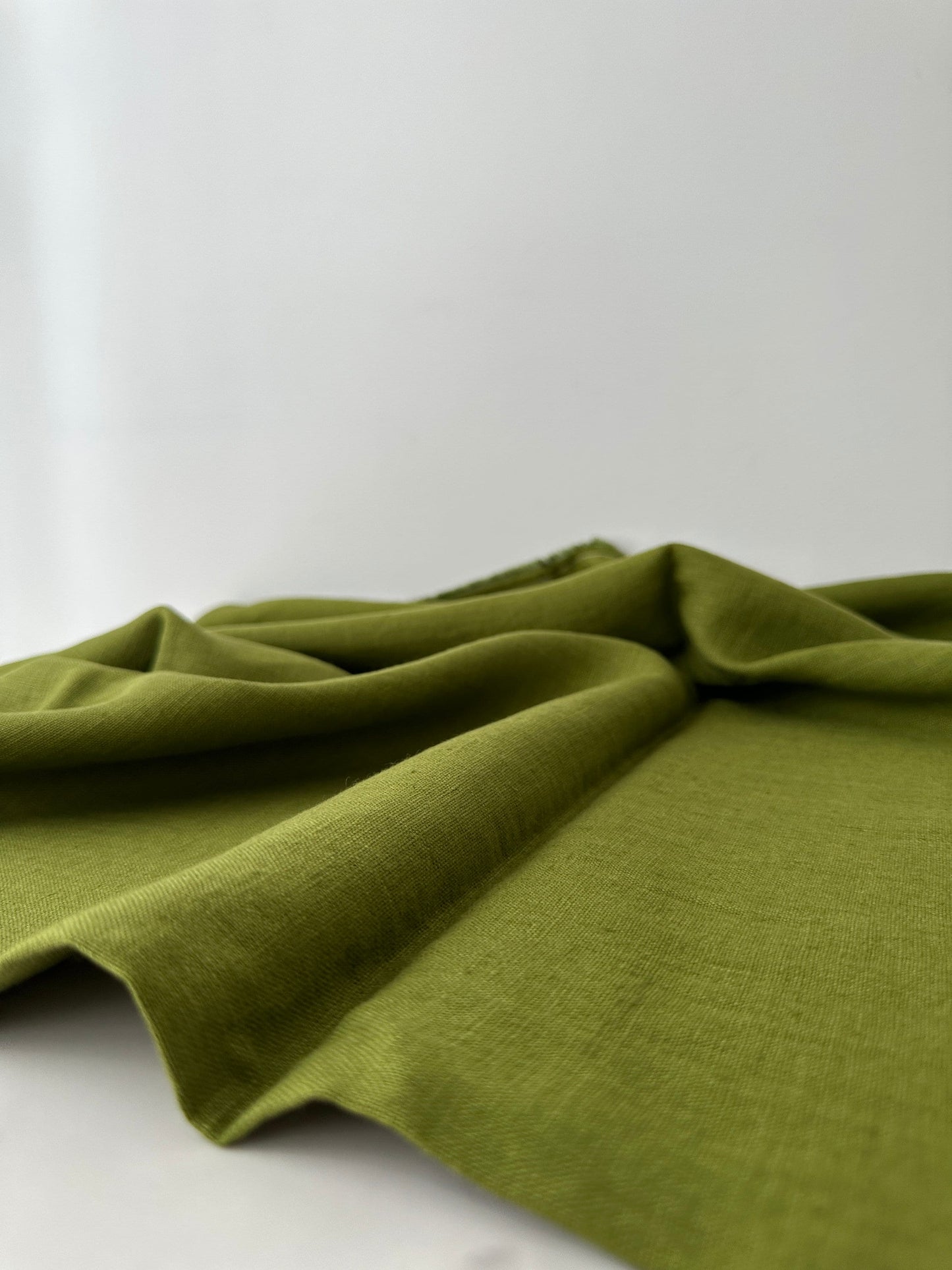 olive green line fabric flat and resting on table