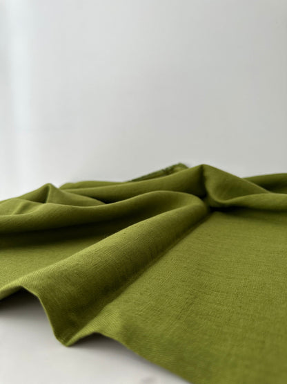 olive green line fabric flat and resting on table