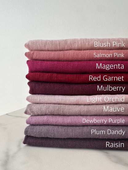 complete color palette of pink and purple European linen fabric folded nicely on flat surface