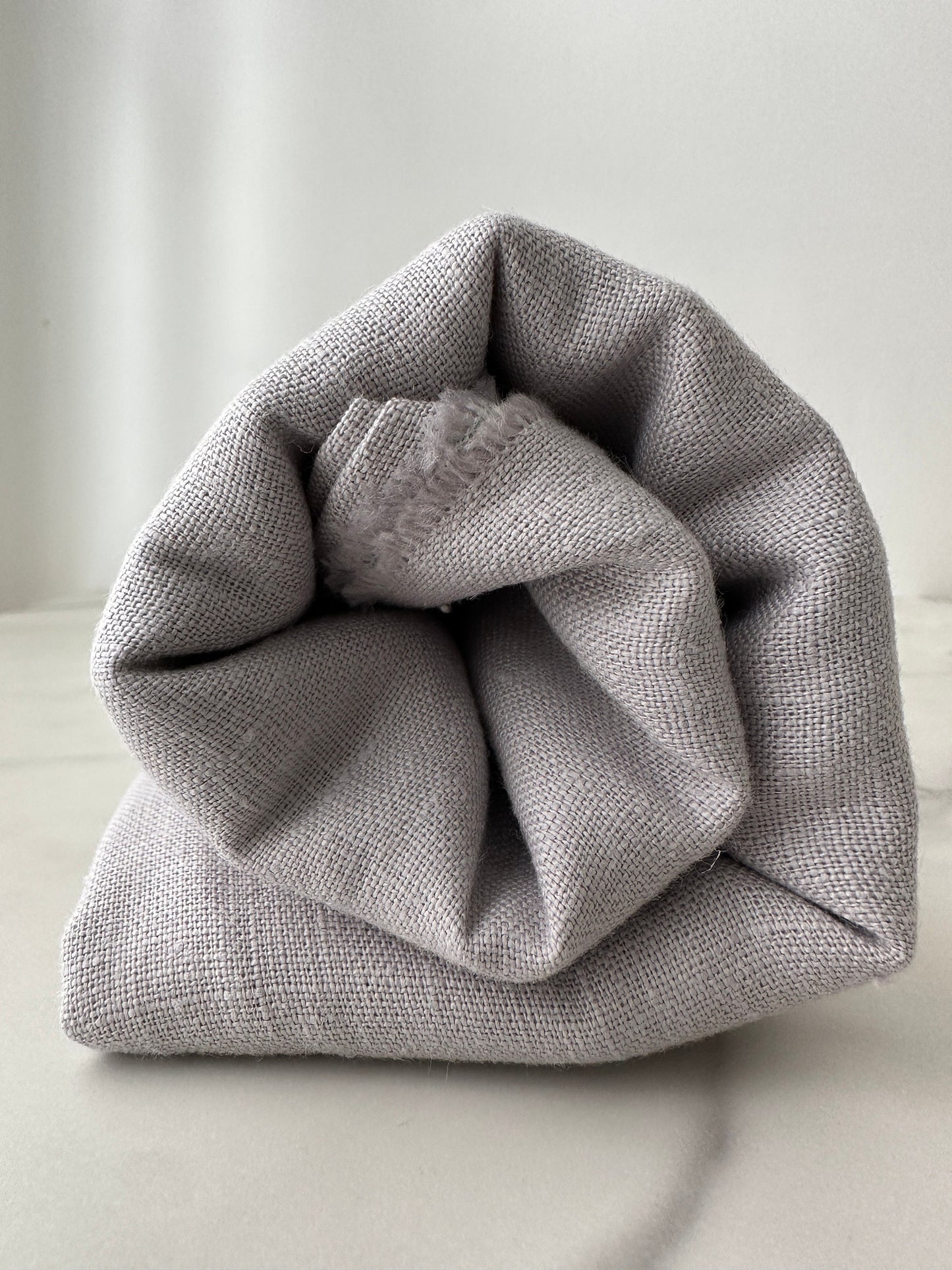 dove gray linen fabric rolled for presentation