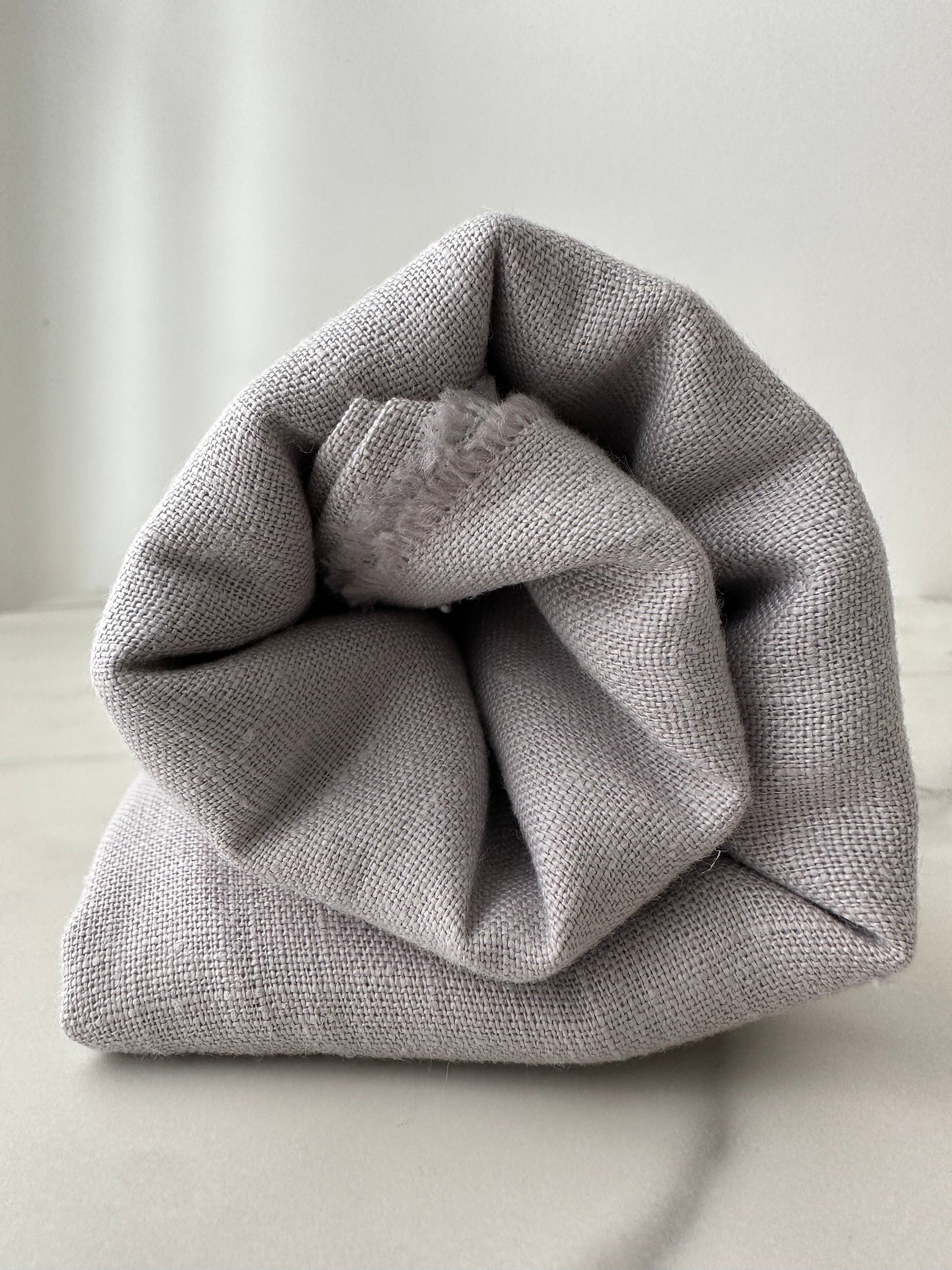dove gray linen fabric rolled for presentation